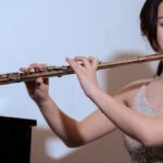 Solo Living - Ethnic woman in dress playing flute at concert